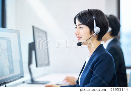 A female operator who wears a headset in the office and responds 98955144