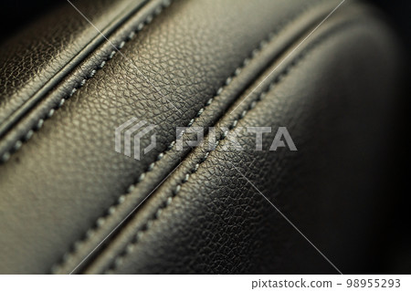 High angle view of modern car fabric seats. Close-up car seat texture and interior details. Detailed image of a car pleats stitch work. Leather seats. High angle view of modern car fabric seats. Close-up car seat texture and interior details. Detailed image of a car pleats stitch work. Leather seats. 98955293