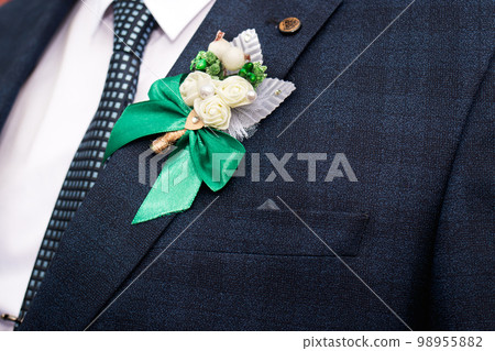 Beautiful wedding boutonniere of rose on a blue jacket at the groom's wedding day. 98955882