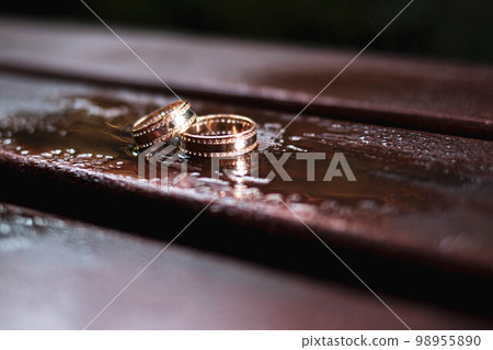 Gold rings with stones on a brown background Gold rings with stones on a brown background 98955890