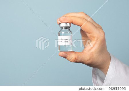 A doctor or laboratory technician keeps the Prevenar vaccine on a blue background. Vaccination against pneumocococy, prevention of pneumonia in infants A doctor or laboratory technician keeps the Prevenar vaccine on a blue background. Vaccination against pneumocococy, prevention of pneumonia in infants 98955993
