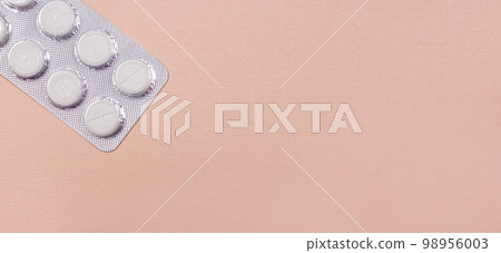 The tablets are packaged on a beige light background with a place copy space to text a banner for a medical clinic. Medicine and pharmacy, disease treatment The tablets are packaged on a beige light background with a place copy space to text a banner for a medical clinic. Medicine and pharmacy, disease treatment 98956003