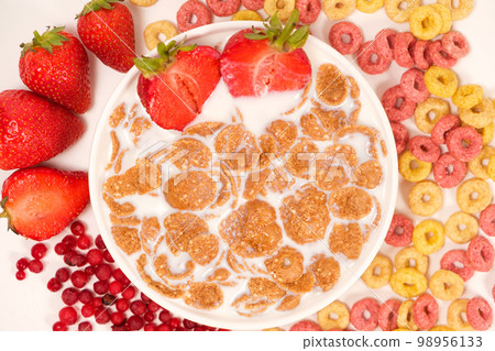 Cereals drenched in milk - quick breakfast with fruits and berries, top view Cereals drenched in milk - quick breakfast with fruits and berries, top view 98956133