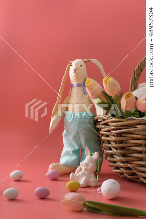 Easter bunny near basket and eggs 98957304