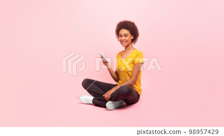 Cheerful millennial multiethnic woman in casual typing on smartphone, chatting, watch video, surfing internet Cheerful millennial multiethnic woman in casual typing on smartphone, chatting, watch video, surfing internet 98957429