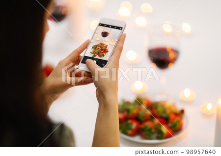 Unrecognizable brunette woman taking photo of festive table 98957640