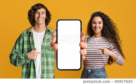 Mobile Mockup. Happy Young Couple Pointing At Cellphone With Blank Screen 98957685