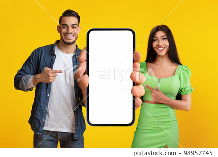 Special Offer. Smiling Middle Eastern Couple Demonstrating Blank Smartphone With White Screen Special Offer. Smiling Middle Eastern Couple Demonstrating Blank Smartphone With White Screen 98957745