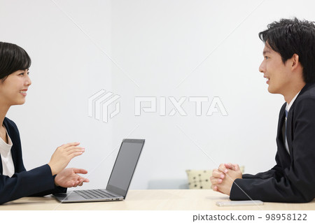 Businessman 2 who puts his hands together and listens with interest to a businesswoman's proposal 98958122