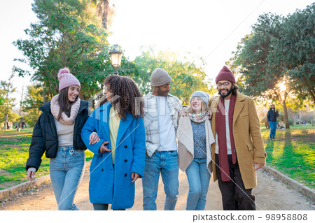 Cheerful group of students walking outdoors in the campus University college having fun together.  98958808