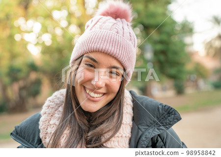 Young joyful woman smiling at camera outdoors on a sunny day in the park. Traveler girl. Young joyful woman smiling at camera outdoors on a sunny day in the park. Traveler girl. 98958842