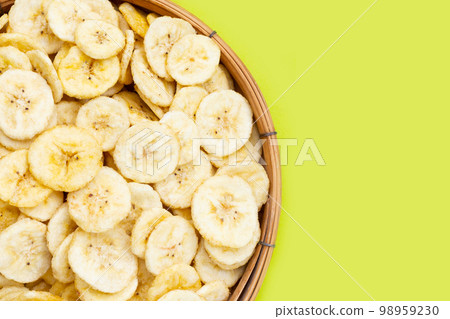 Banana slice chips on green background. 98959230