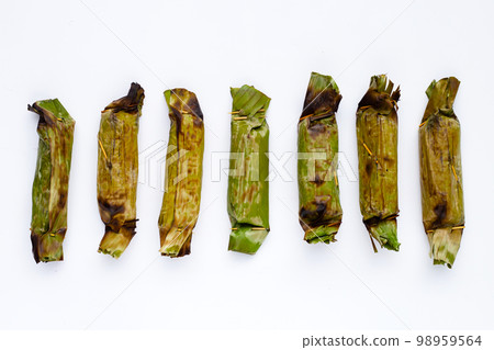 Grilled sticky rice in banana leaves with banana filling Grilled sticky rice in banana leaves with banana filling 98959564