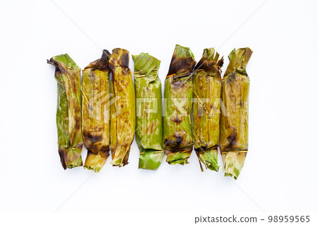 Grilled sticky rice in banana leaves with banana filling Grilled sticky rice in banana leaves with banana filling 98959565