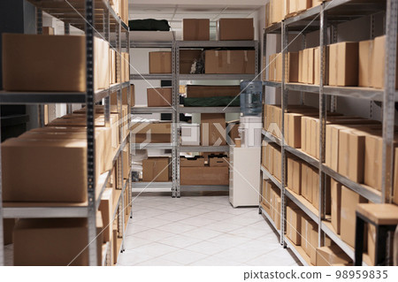 Cardboard boxes stacks on empty delivery service warehouse room shelves. Goods packages on racks structure in factory industry logistic department storehouse with nobody inside Cardboard boxes stacks on empty delivery service warehouse room shelves. Goods packages on racks structure in factory industry logistic department storehouse with nobody inside 98959835