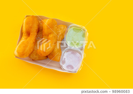 Deep-fried dough sticks or chinese bread sticks on yellow background. Deep-fried dough sticks or chinese bread sticks on yellow background. 98960083