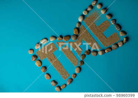Word Time made of sand in the shape of hourglass on blue background. Flat lay. Copy space 98960399