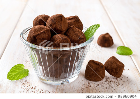 Chocolate truffles in a glass bowl closeup. 98960904