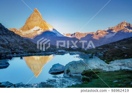 Reflection of the Matterhorn on blue lake at sunrise, Swiss Alps, Zermatt Reflection of the Matterhorn on blue lake at sunrise, Swiss Alps, Zermatt 98962419