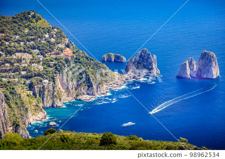 Above Capri city cliffs and Faraglioni with boats and yacht, amalfi coast, Italy Above Capri city cliffs and Faraglioni with boats and yacht, amalfi coast, Italy 98962534