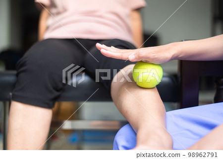 Physiotherapist massage leg patient with tennis ball at clinic,Physical therapy concept Physiotherapist massage leg patient with tennis ball at clinic,Physical therapy concept 98962791