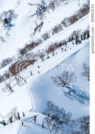 Tomi ridge trekking in winter (climbers going along the ridgeline) 98962818