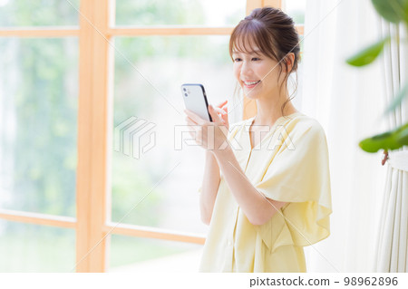 A woman watching a smartphone A woman watching a smartphone 98962896
