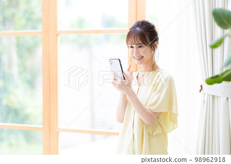 觀看智能手機的婦女 觀看智能手機的婦女 98962918