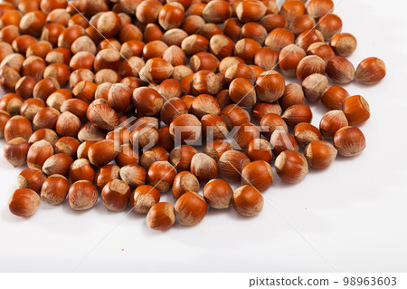 Heap of raw hazelnuts on white 98963603