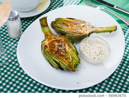 Delicious fried artichoke halves with coarse salt on a white plate Delicious fried artichoke halves with coarse salt on a white plate 98963670