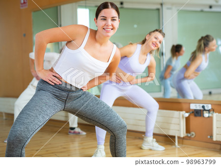 Active young woman practicing aerobic dance in training hall 98963799