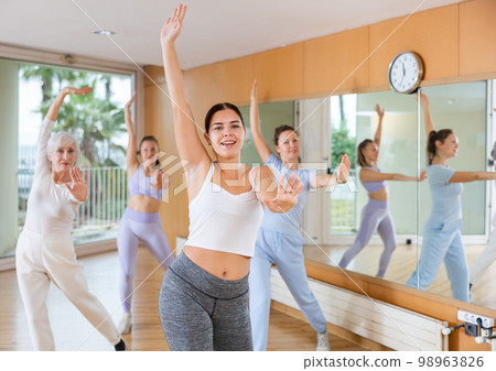 Women learning modern dance movements at class together 98963826