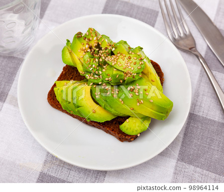 Sandwich with pieces of fresh avocado 98964114