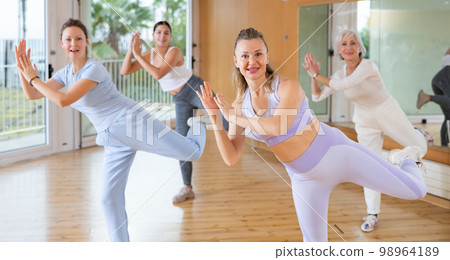 Active middle-aged woman practicing aerobic dance in training hall Active middle-aged woman practicing aerobic dance in training hall 98964189