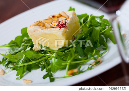 Camembert with arugula and pine nuts Camembert with arugula and pine nuts 98964385