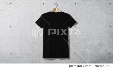 混凝土牆上衣架上的一件普通黑色 T 卹 98965069