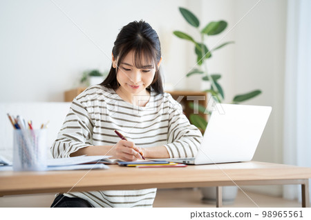 Woman checking household account book with inflation Woman checking household account book with inflation 98965561