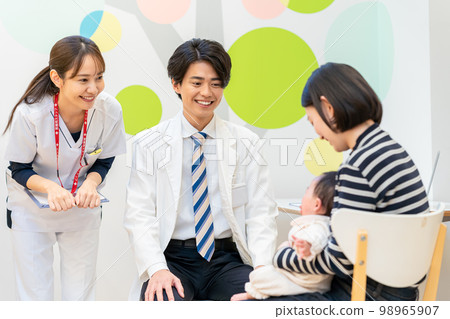 Doctor examining a baby 98965907