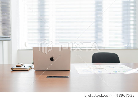Notebooks and meeting materials placed in a lighted meeting room Notebooks and meeting materials placed in a lighted meeting room 98967533
