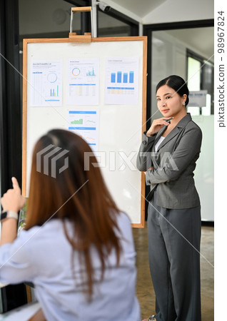 Confident Asian businesswoman or financial analyst manager leads the financial meeting Confident Asian businesswoman or financial analyst manager leads the financial meeting 98967824