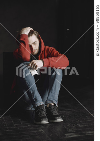 Young addicted man with cocain packet sitting alone 98968165