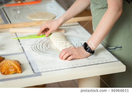 Top view of female hands with electronic fitness bracelet preparing homemade cakes 98968631