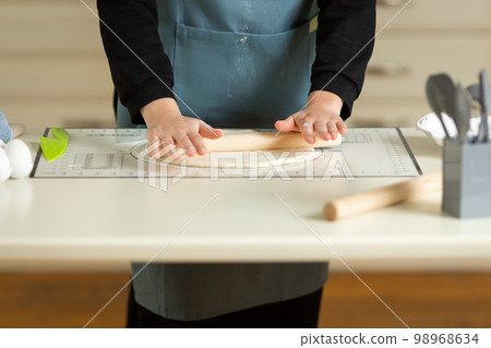Cooking dough products on a large kitchen table on a kitchen silicone mat with copy space 98968634