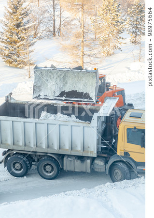 Cleaning and cleaning of roads in the city from snow in winter Cleaning and cleaning of roads in the city from snow in winter 98975664
