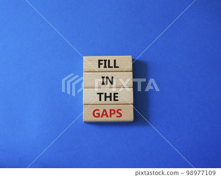 Fill in the gaps symbol. Concept words fill in the gaps on wooden blocks. Beautiful blue background. Business and fill in the gaps concept. Copy space. 98977109