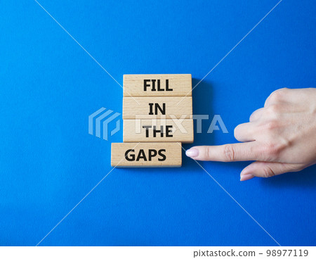 Fill in the gaps symbol. Concept words fill in the gaps on wooden blocks. Beautiful blue background. Business and fill in the gaps concept. Copy space. Fill in the gaps symbol. Concept words fill in the gaps on wooden blocks. Beautiful blue background. Business and fill in the gaps concept. Copy space. 98977119