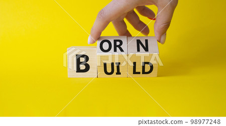 Born and Build symbol. Businessman hand turns wooden cubes and changes word Build to Born. Beautiful yellow background. Business and Born and Build concept. Copy space. Born and Build symbol. Businessman hand turns wooden cubes and changes word Build to Born. Beautiful yellow background. Business and Born and Build concept. Copy space. 98977248