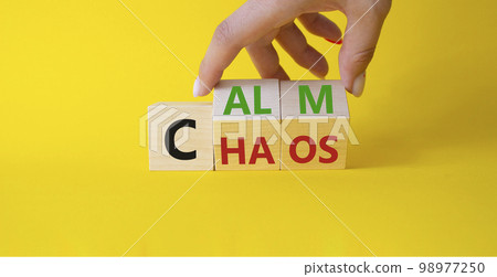 Calm vs chaos symbol. Businessman hand turns wooden cubes and changes word Chaos to Calm. Beautiful yellow background. Business and Calm vs chaos concept. Copy space. 98977250