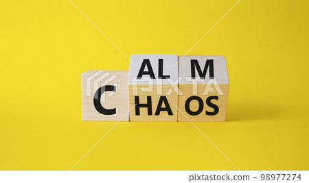 Calm vs chaos symbol. Turned wooden cubes with words Chaos and Calm. Beautiful yellow background. Business and Calm vs chaos concept. Copy space. 98977274