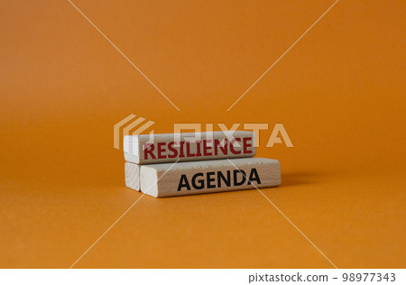 Resilience agenda symbol. Wooden blocks with words Resilience agenda. Beautiful orange background. Business and Resilience agenda concept. Copy space. 98977343